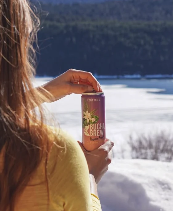 Enjoying a can of Bucha Brew Passion Fruit beside a mountain lake